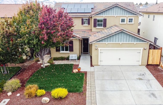 view of front of property with a front lawn, a garage, and solar panels