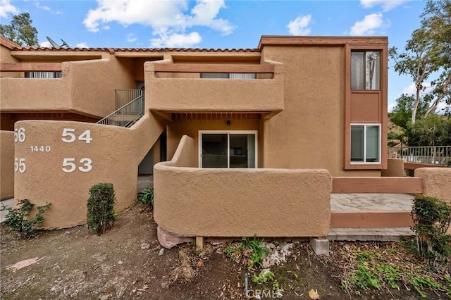 exterior space featuring stucco siding and a balcony