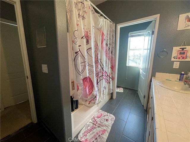 bathroom featuring tile patterned flooring, vanity, and shower / bathtub combination with curtain