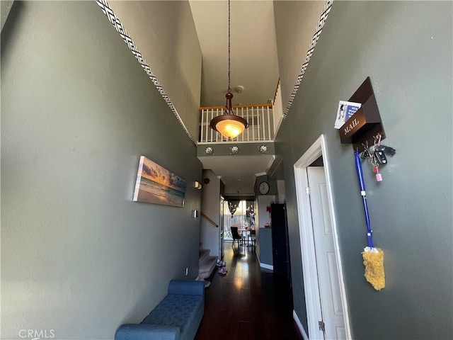 corridor featuring a high ceiling and wood-type flooring