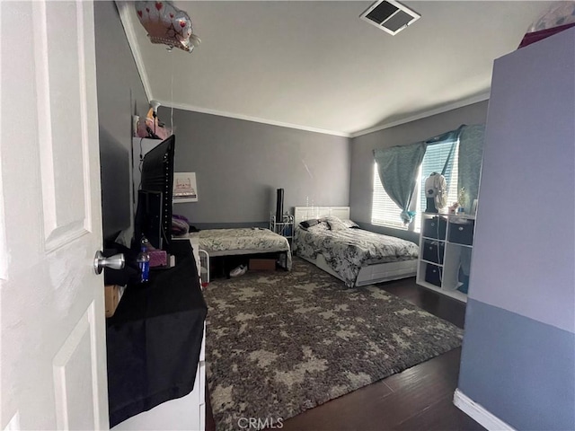 bedroom featuring crown molding and dark hardwood / wood-style floors