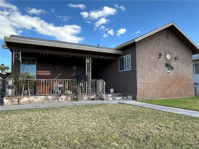 view of front of home featuring covered porch and a front lawn