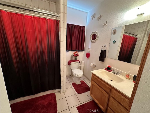 bathroom featuring tile patterned floors, vanity, toilet, and walk in shower