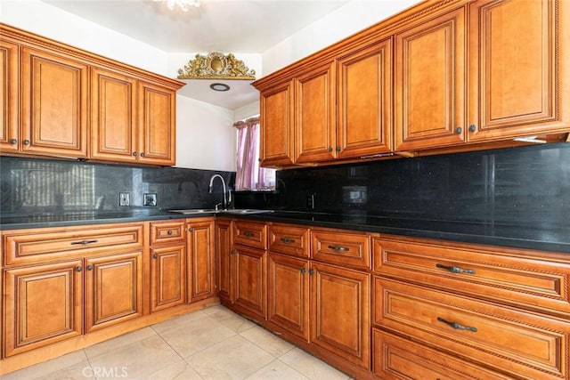 1748 N Kenmore Ave Unit 203, Los Angeles, CA 90027 - kitchen featuring a sink, brown cabinets, light tile patterned floors, tasteful backsplash, and dark countertops