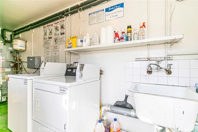 laundry room featuring separate washer and dryer, gas water heater, and sink