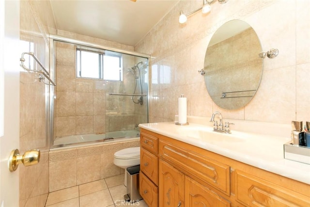 full bathroom featuring vanity, tile walls, enclosed tub / shower combo, tile patterned flooring, and toilet