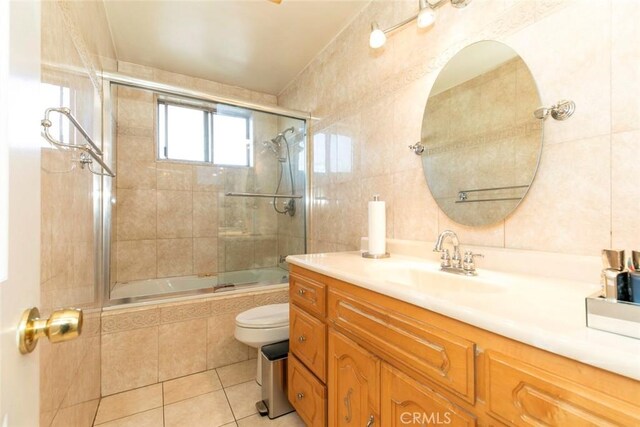 1748 N Kenmore Ave Unit 203, Los Angeles, CA 90027 - bathroom with tiled shower / bath combo, toilet, vanity, tile patterned floors, and tile walls