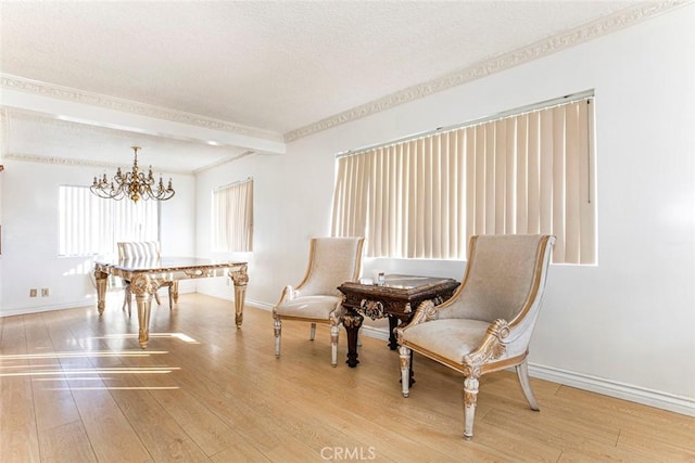 living area featuring beamed ceiling, wood-type flooring, a textured ceiling, and a notable chandelier