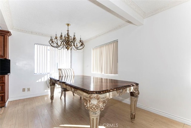 dining space with a textured ceiling, light wood-type flooring, crown molding, and a notable chandelier