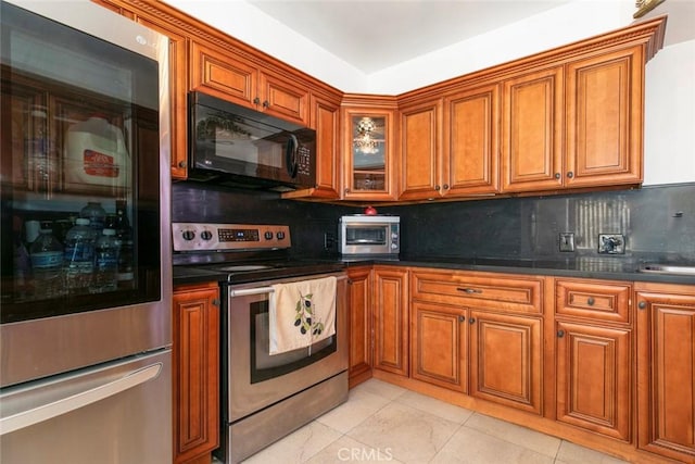1748 N Kenmore Ave Unit 203, Los Angeles, CA 90027 - kitchen featuring refrigerator, black microwave, stainless steel electric range, and brown cabinetry