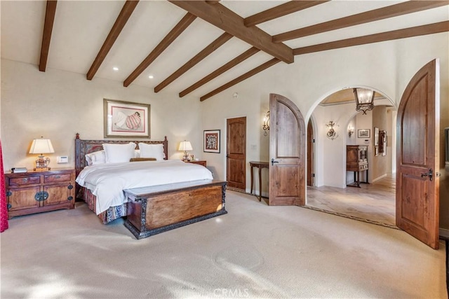 bedroom featuring light carpet and lofted ceiling with beams