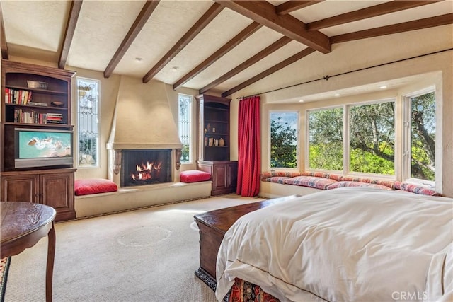 carpeted bedroom featuring lofted ceiling with beams and a fireplace