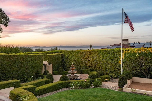 yard at dusk featuring a mountain view