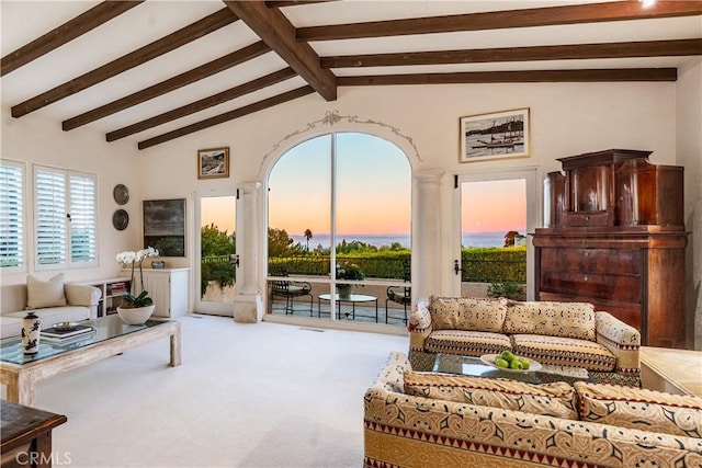 carpeted living room with beam ceiling and high vaulted ceiling