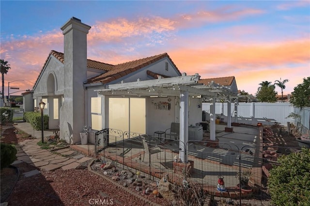 back house at dusk featuring a patio area and a pergola