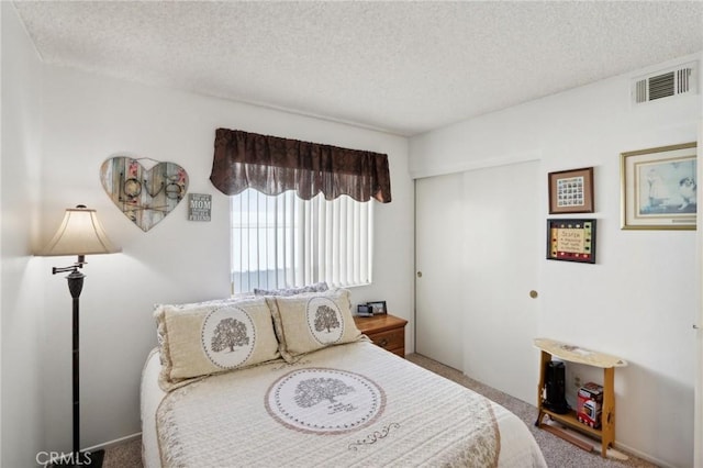 carpeted bedroom with a textured ceiling