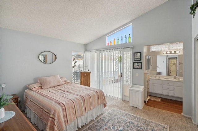 carpeted bedroom featuring access to outside, ensuite bath, high vaulted ceiling, and a textured ceiling