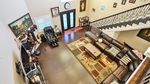 living room with wood-type flooring and a towering ceiling