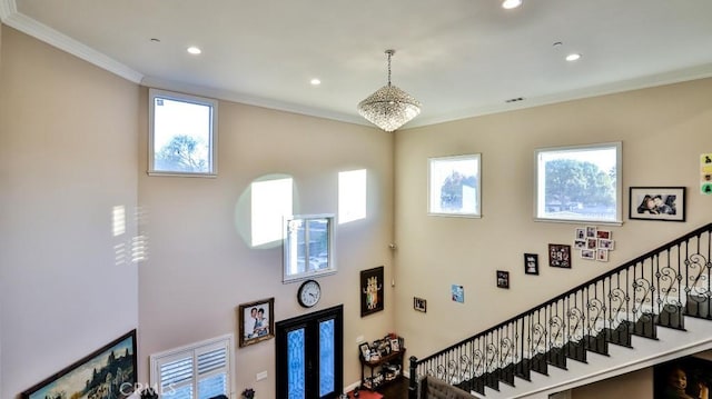 staircase featuring a chandelier, ornamental molding, and a healthy amount of sunlight