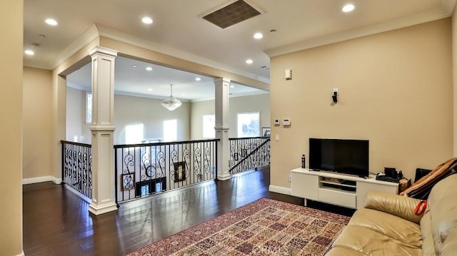 living room with dark hardwood / wood-style flooring, an inviting chandelier, and crown molding