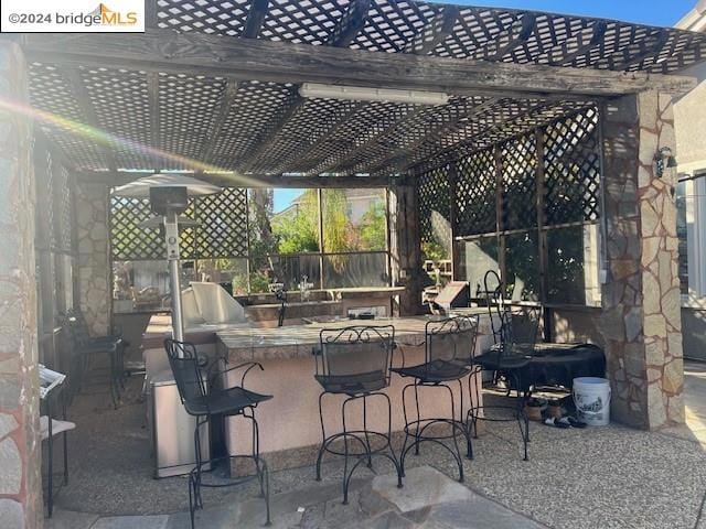 view of patio / terrace featuring a pergola and exterior bar