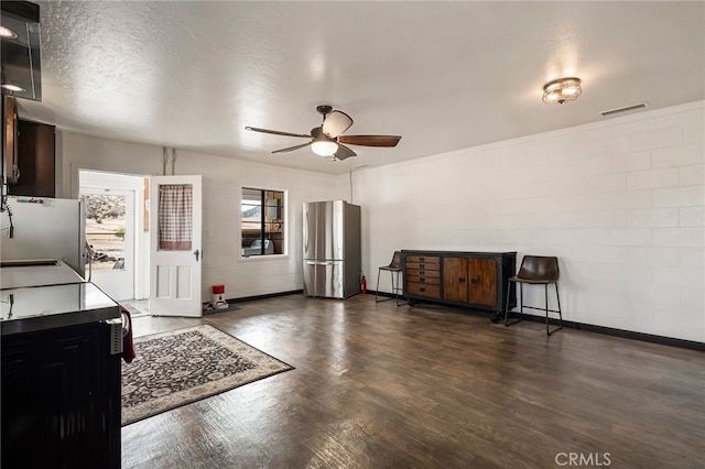 kitchen featuring fridge, a textured ceiling, ceiling fan, stainless steel fridge, and dark wood-type flooring