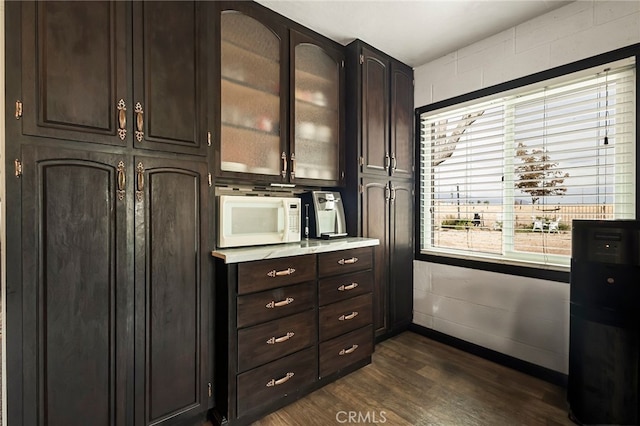 interior space with dark hardwood / wood-style flooring and dark brown cabinetry