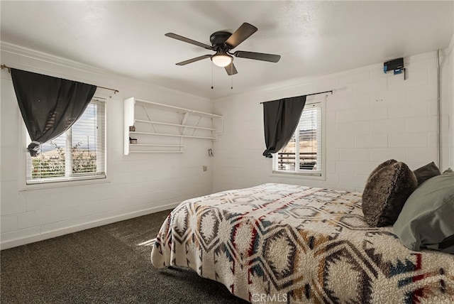 bedroom with baseboards, a ceiling fan, carpet, and concrete block wall