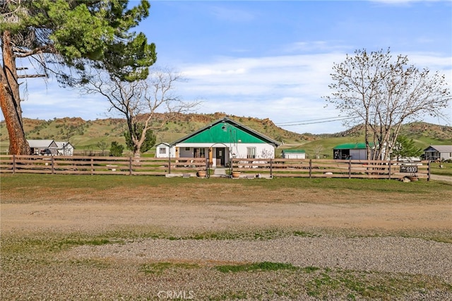 view of community featuring a rural view, fence, and a mountain view