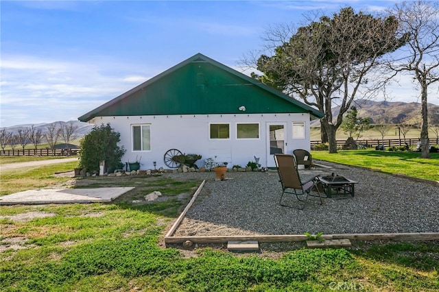 back of house with a yard, a patio, a fire pit, and a mountain view