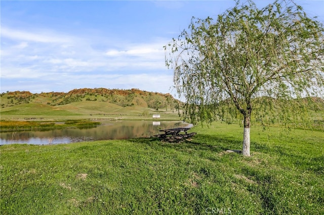 surrounding community featuring a lawn and a water view