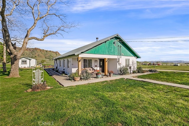 rear view of house with a mountain view and a lawn