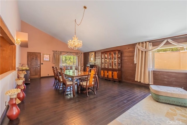 dining room with wooden walls, high vaulted ceiling, dark hardwood / wood-style floors, and an inviting chandelier