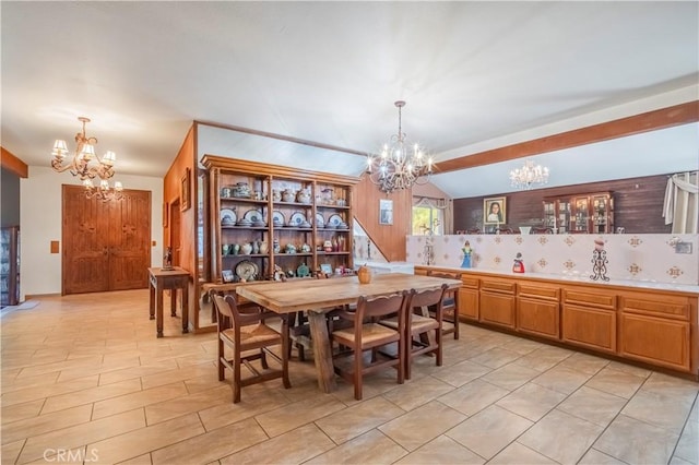 dining space featuring vaulted ceiling and an inviting chandelier