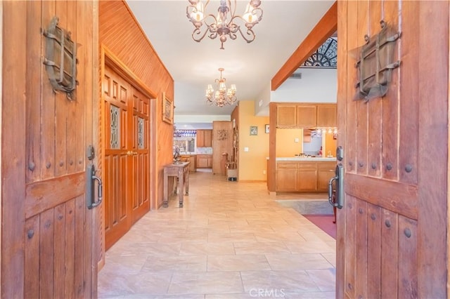 foyer featuring wooden walls and a chandelier