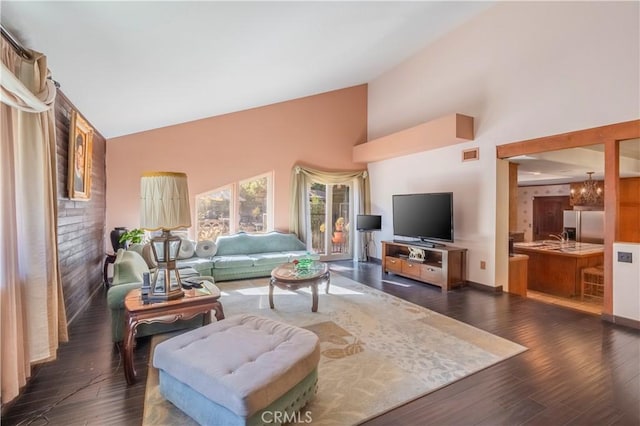 living room featuring high vaulted ceiling and dark wood-type flooring