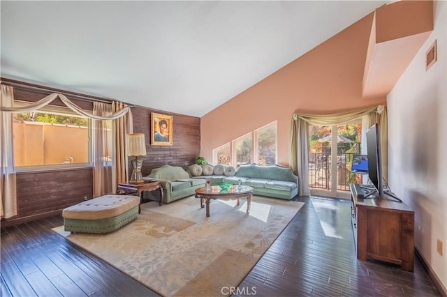 living room with wooden walls, dark hardwood / wood-style flooring, and vaulted ceiling