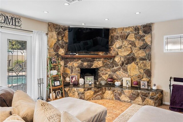 tiled living room featuring plenty of natural light and a fireplace