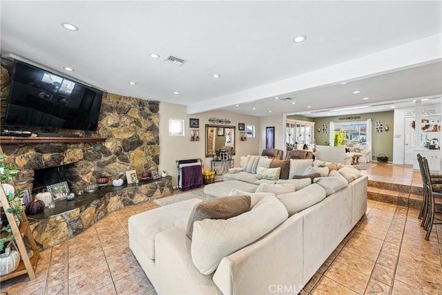 living room with beamed ceiling, light tile patterned flooring, and a fireplace