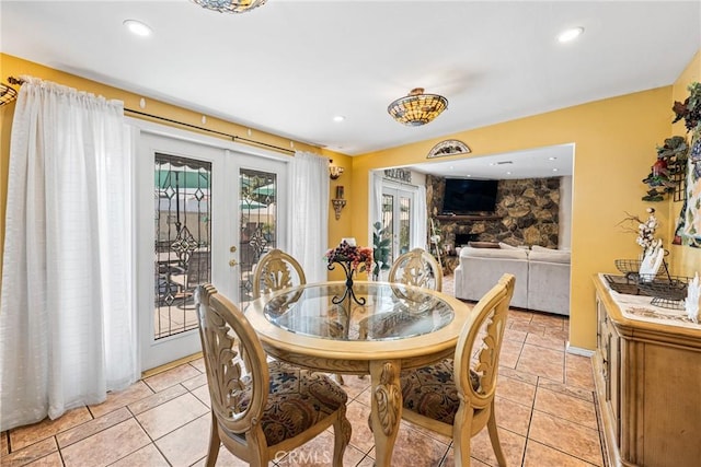 tiled dining space featuring a fireplace and french doors