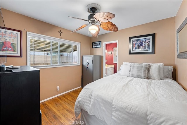 bedroom with ceiling fan, connected bathroom, and light hardwood / wood-style flooring