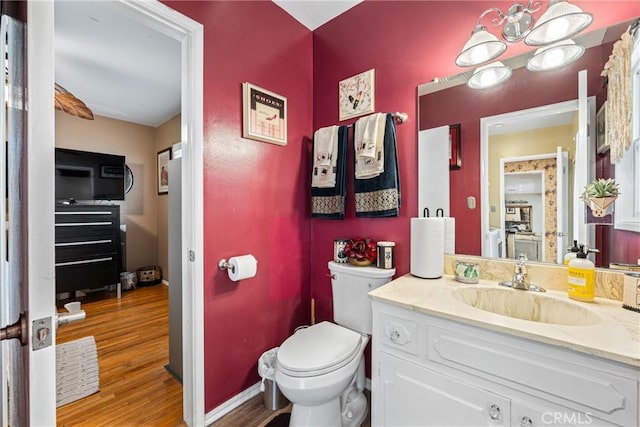 bathroom featuring toilet, vanity, and hardwood / wood-style flooring