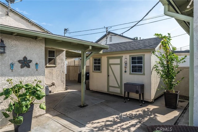 back of house featuring a patio area and an outbuilding