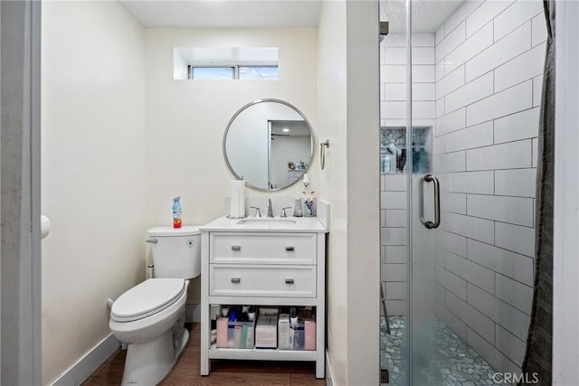 bathroom featuring vanity, toilet, a shower with door, and wood-type flooring