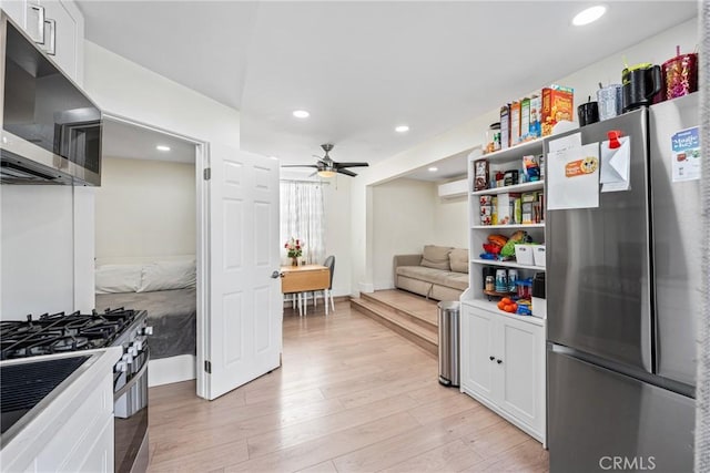 kitchen with ceiling fan, white cabinets, light hardwood / wood-style floors, and appliances with stainless steel finishes