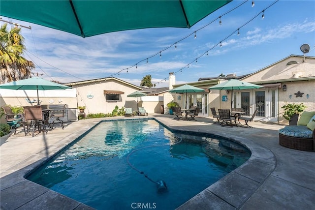 view of swimming pool with french doors and a patio area