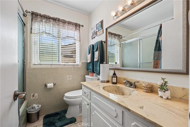 bathroom with tile patterned floors, plenty of natural light, tile walls, and vanity