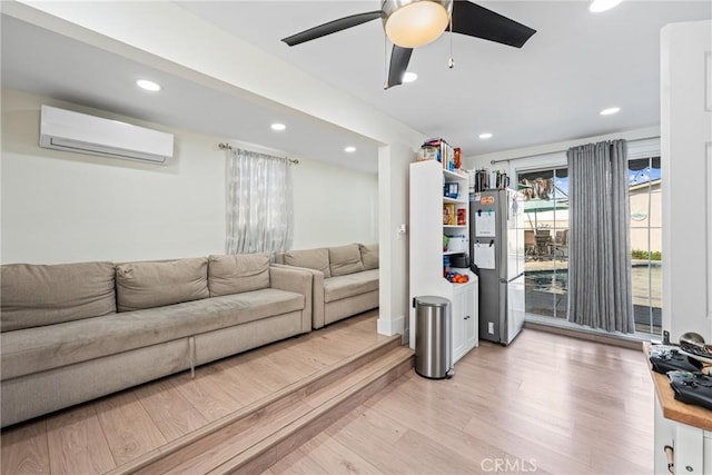 living room featuring an AC wall unit, ceiling fan, and light wood-type flooring