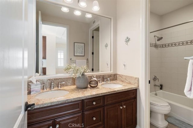 full bathroom featuring vanity, toilet, and tiled shower / bath