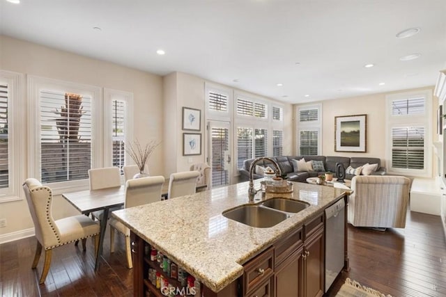 kitchen with dishwasher, a healthy amount of sunlight, sink, and an island with sink